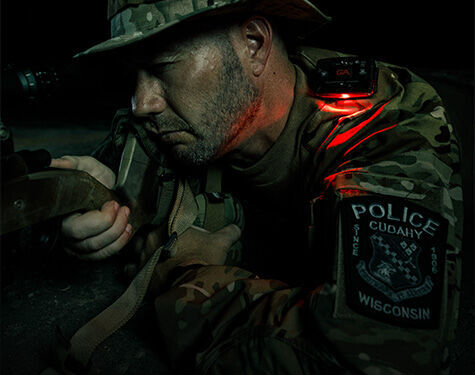 police officer wearing a safety light device while looking through a scope