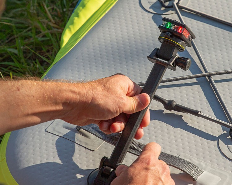 Kayaker installing a guardian angel light on a stick mount