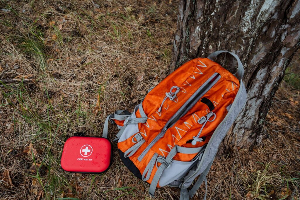First aid kid next to a backpack in the wilderness