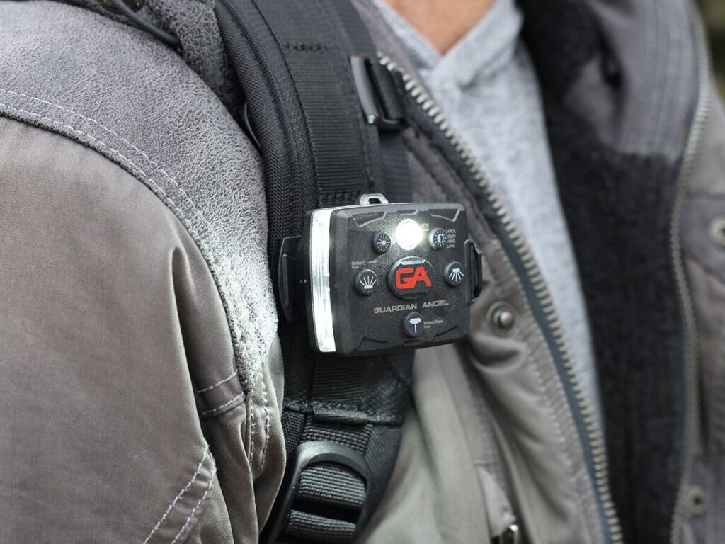 A Guardian Angel light attached to a backpack strap