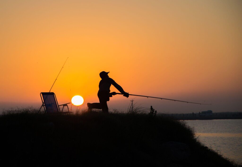The silhouette of a man fishing early in the morning